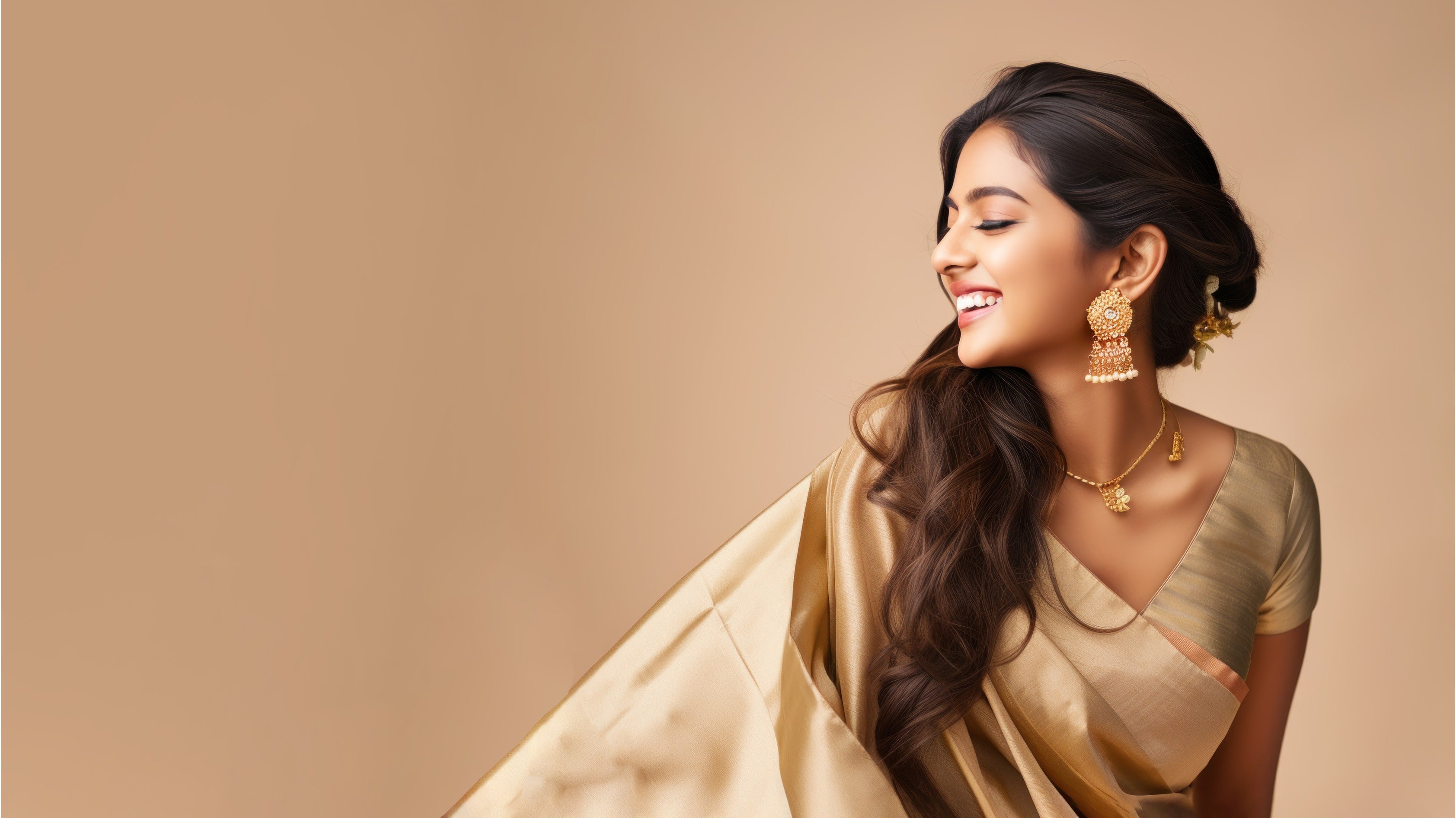 Woman in a gold Tussar silk saree with jewellery against a beige background