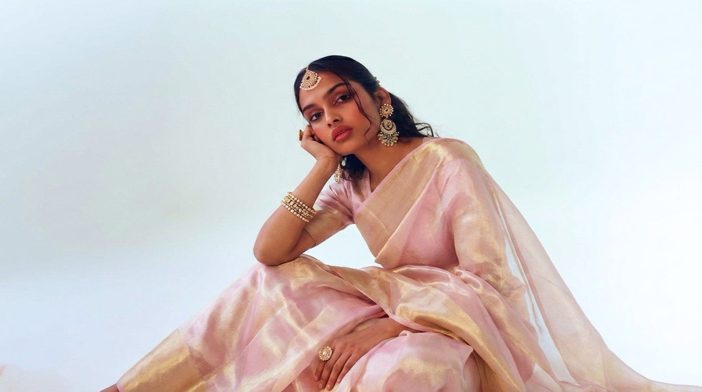 Woman in a light pink saree with a white background
