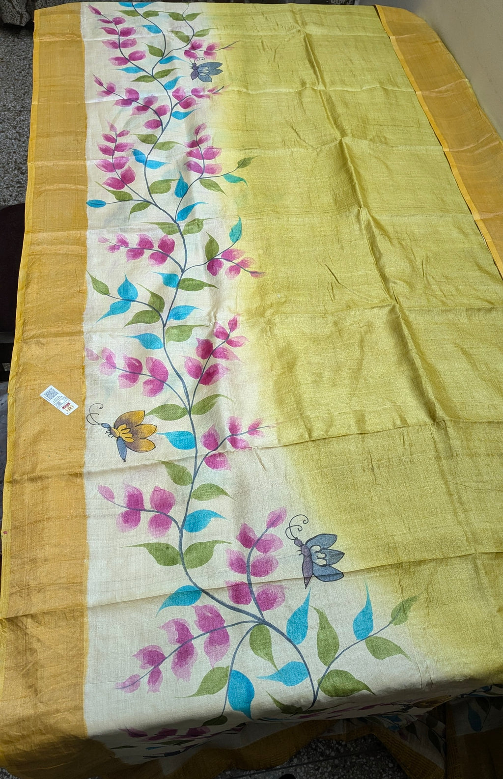 Yellow saree with floral embroidery on a plain background