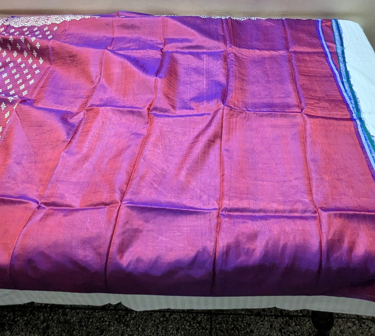 Purple blouse piece of katan silk saree on a table with a neutral background